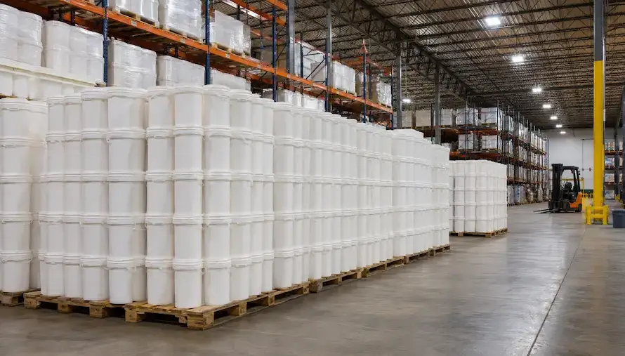 Cubetas de plástico apiladas en pallet en almacén industrial para pedido mayoreo