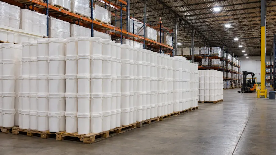 Cubetas de plástico apiladas en pallet en almacén industrial para pedido mayoreo